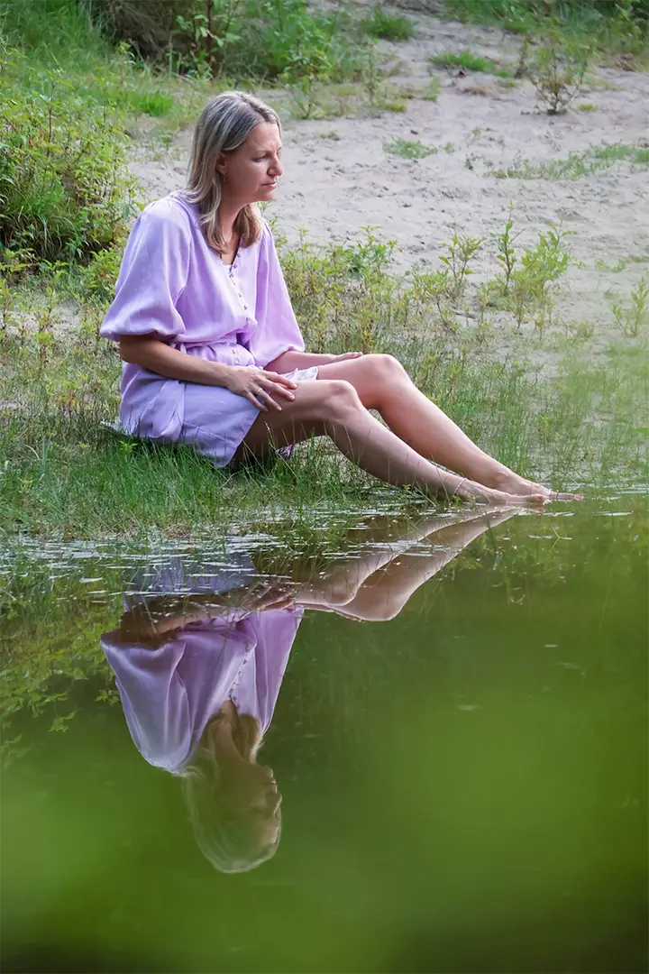 vrouw aan waterrand weerspiegeling water